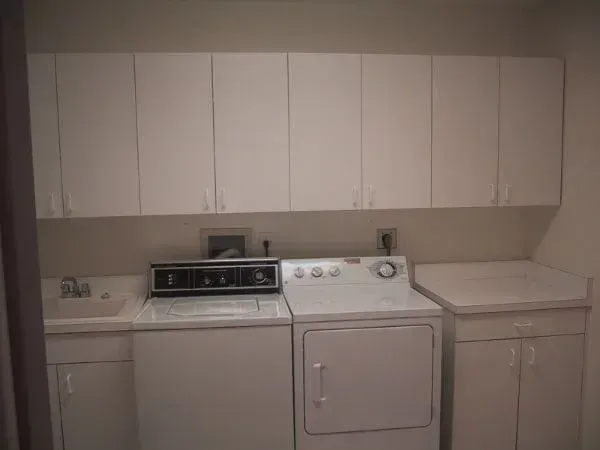 A laundry room with a washer and dryer and a sink