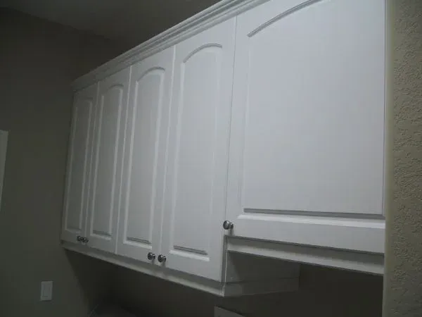 A kitchen with white cabinets and a stove top oven