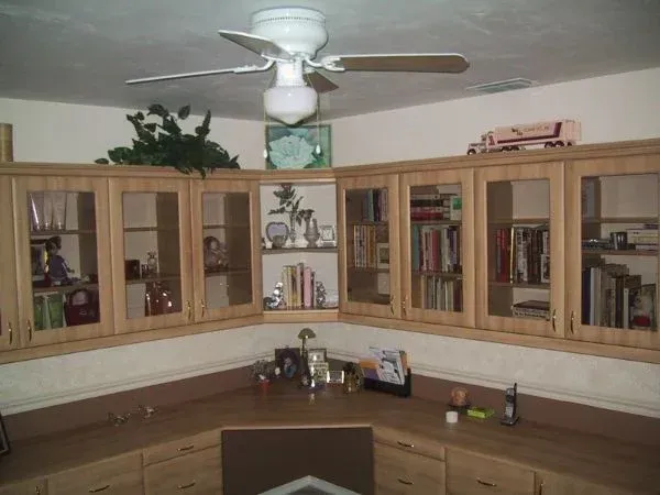 A ceiling fan is hanging from the ceiling above a desk