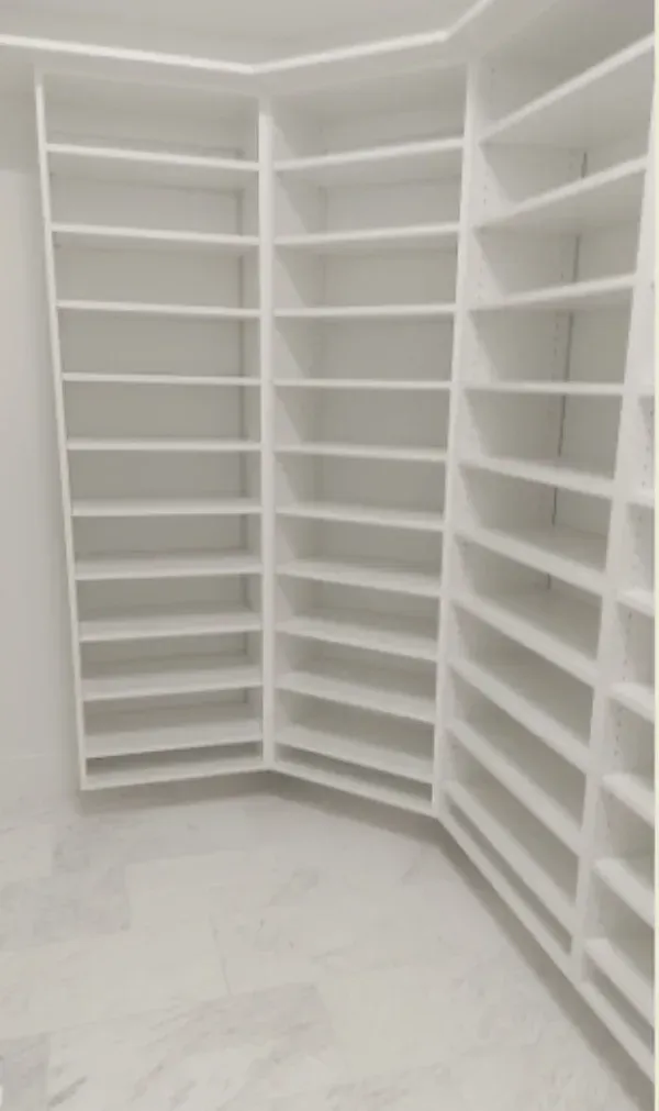 A walk in closet with lots of shelves and a marble floor.