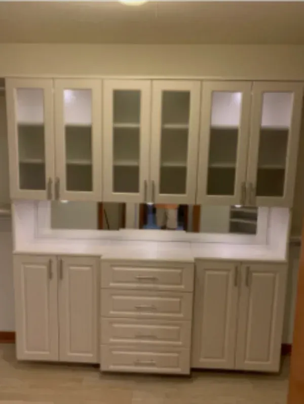 A kitchen with lots of white cabinets and drawers