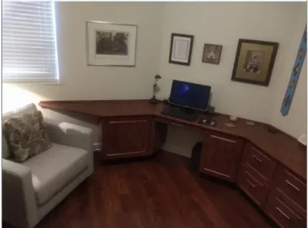A room with a chair and a desk with a laptop on it
