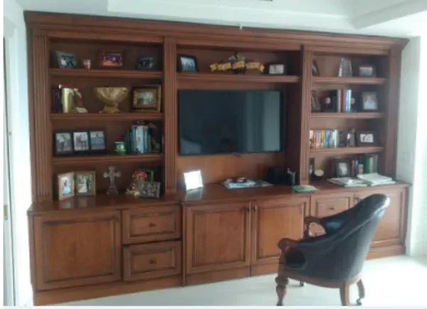 A chair sits in front of a wooden entertainment center