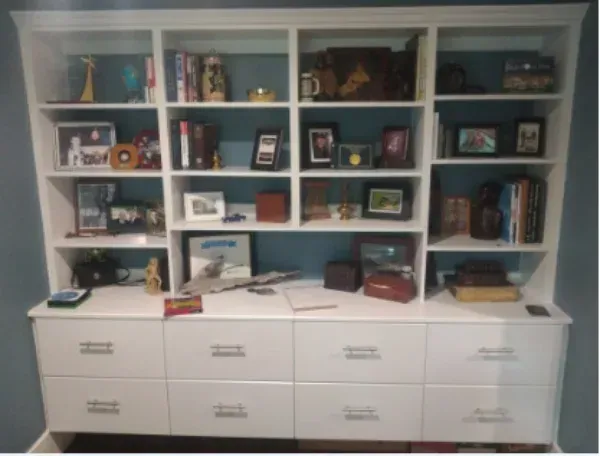 A bookshelf with lots of books and pictures on it