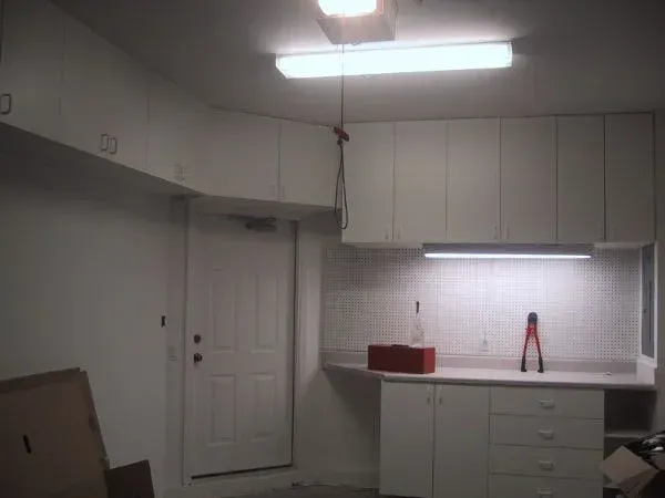 A kitchen with white cabinets and a red box on the counter