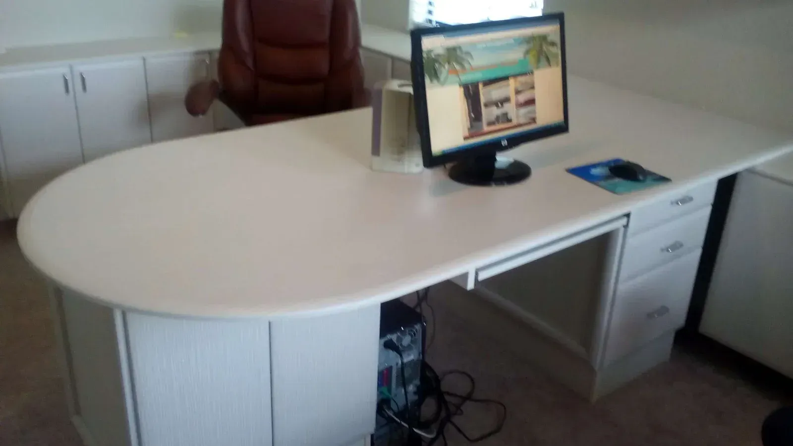 A white desk with a computer on it and a chair
