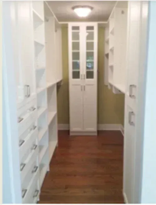 A walk in closet with lots of shelves and drawers
