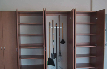A set of shelves with a broom and shovel hanging on them