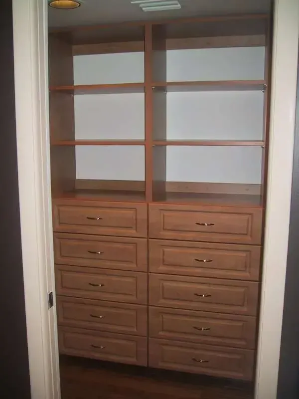 A walk in closet with lots of drawers and shelves.