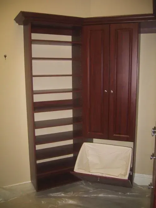 A laundry basket is pulled out of a closet