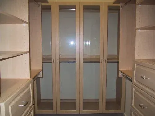 A walk in closet with lots of shelves and drawers