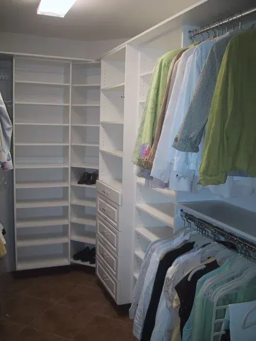 A walk in closet filled with clothes and shelves