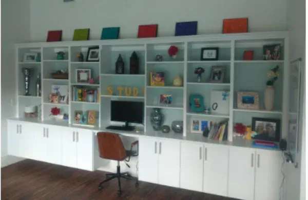 A room with a lot of shelves and a computer desk