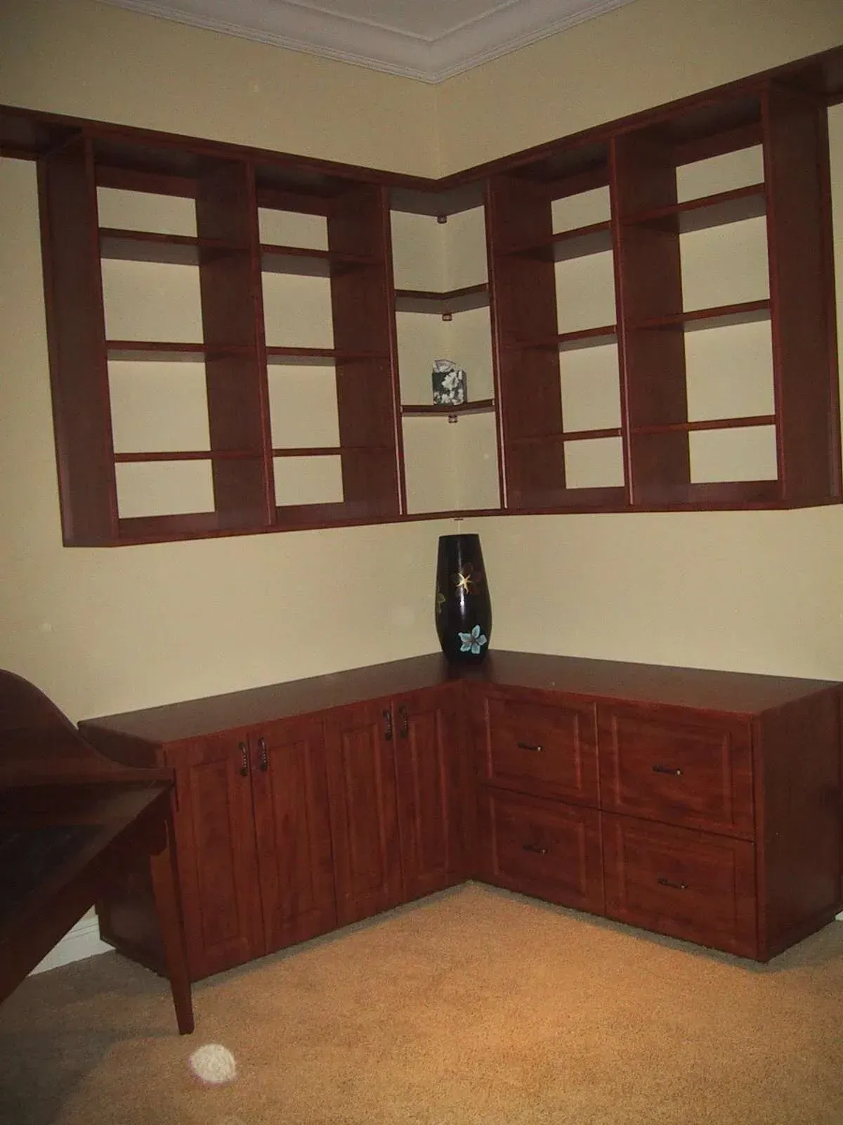 A corner of a room with wooden shelves and drawers