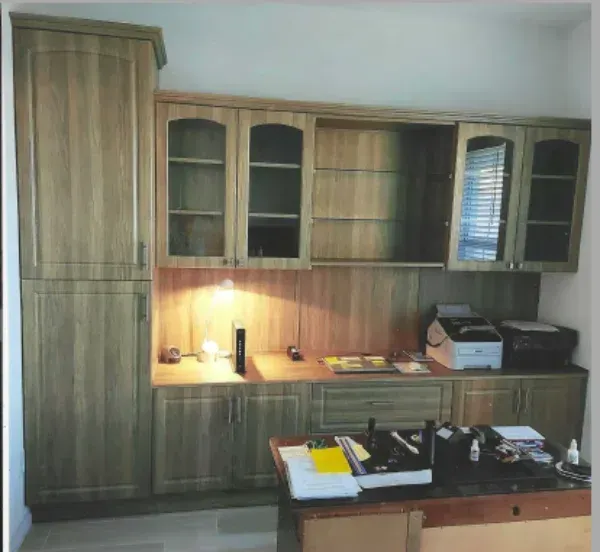 A kitchen with wooden cabinets and a desk