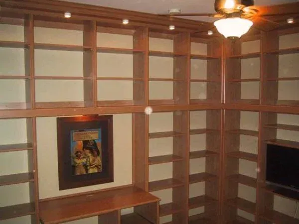 A room with lots of shelves and a picture on the wall