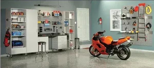 An orange motorcycle is parked in a garage