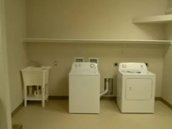 A laundry room with a washer and dryer and a sink