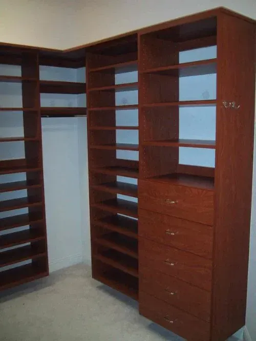 A walk in closet with lots of shelves and drawers