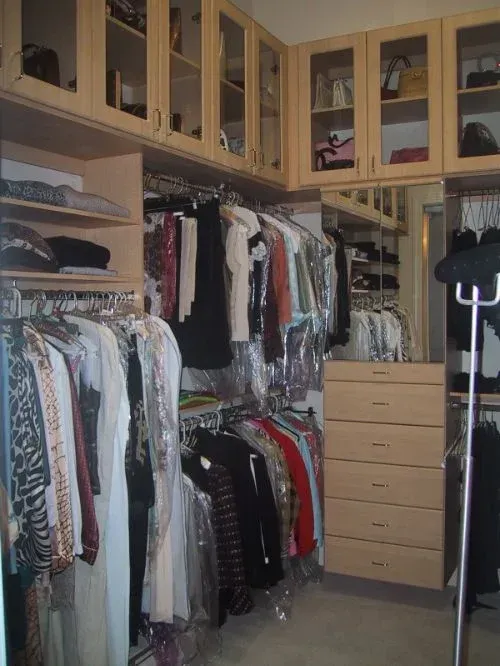 A walk in closet filled with lots of clothes