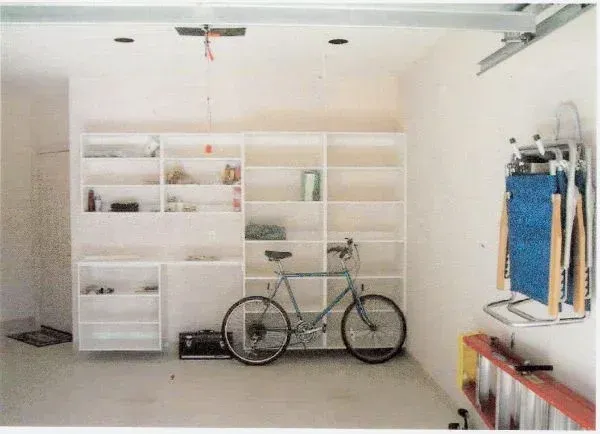 A bicycle is parked on a shelf in a garage