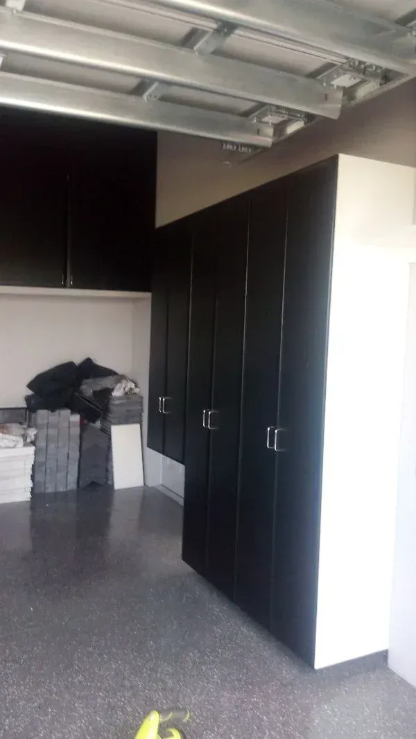 A garage with black cabinets and white walls