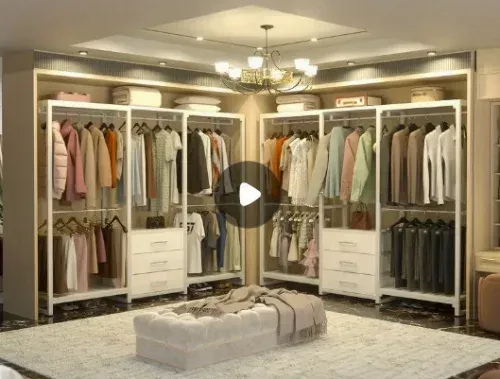 A walk in closet filled with lots of clothes and a white ottoman.