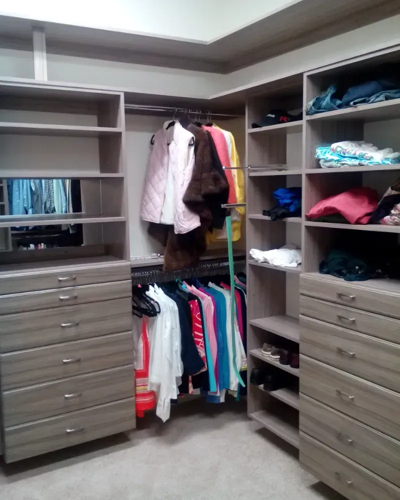 A walk in closet filled with clothes and dressers