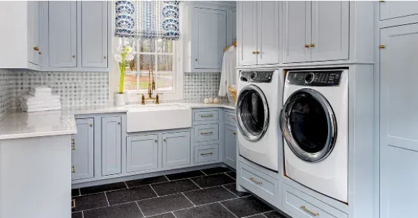 A laundry room with a washer and dryer and a sink.