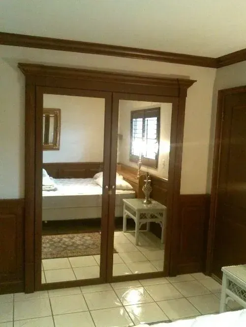 A bedroom with a bed and a mirror on the door