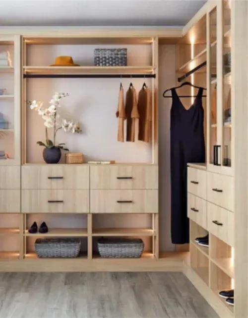 A walk in closet with a black dress hanging on a rack