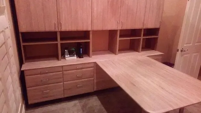 A wooden desk with drawers and cabinets in a room.