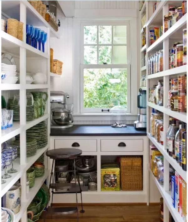 A pantry with lots of shelves and a window