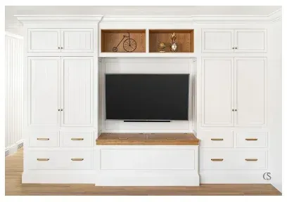 A white entertainment center with a flat screen tv mounted to the wall.