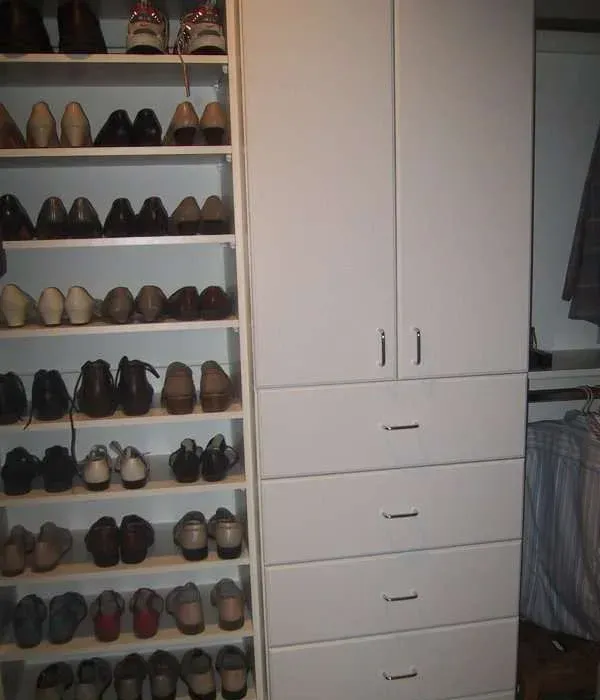 A closet with lots of shoes on shelves and drawers