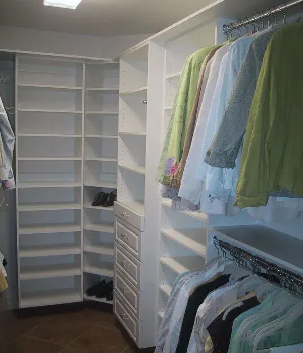A walk in closet filled with clothes and shoes.