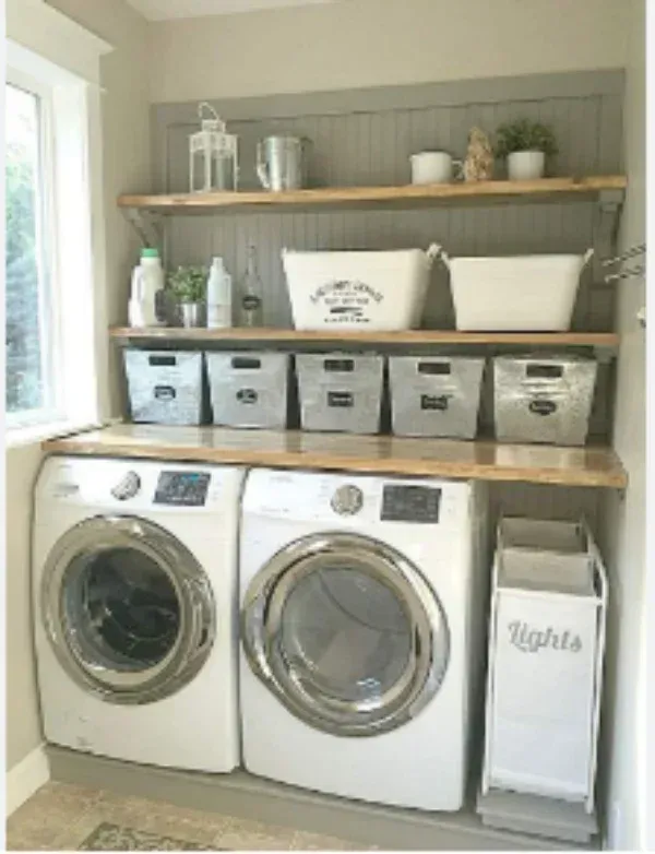 A laundry room with a washer and dryer and shelves.