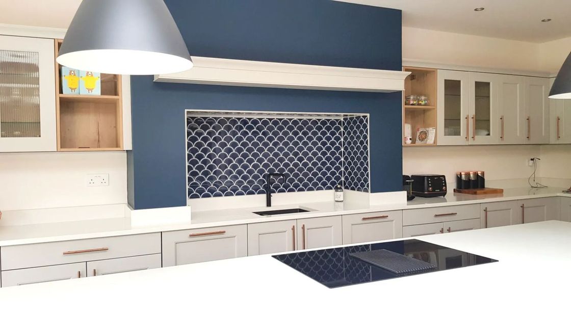 A kitchen with white cabinets and a black stove top oven
