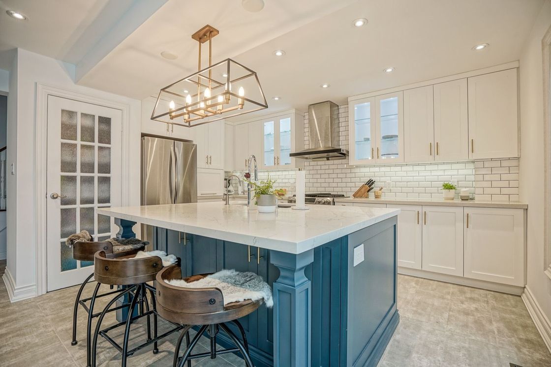 A kitchen with a large island and stools.