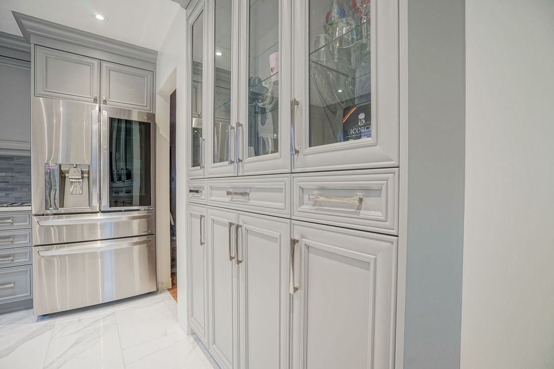 A kitchen with stainless steel appliances and white cabinets.