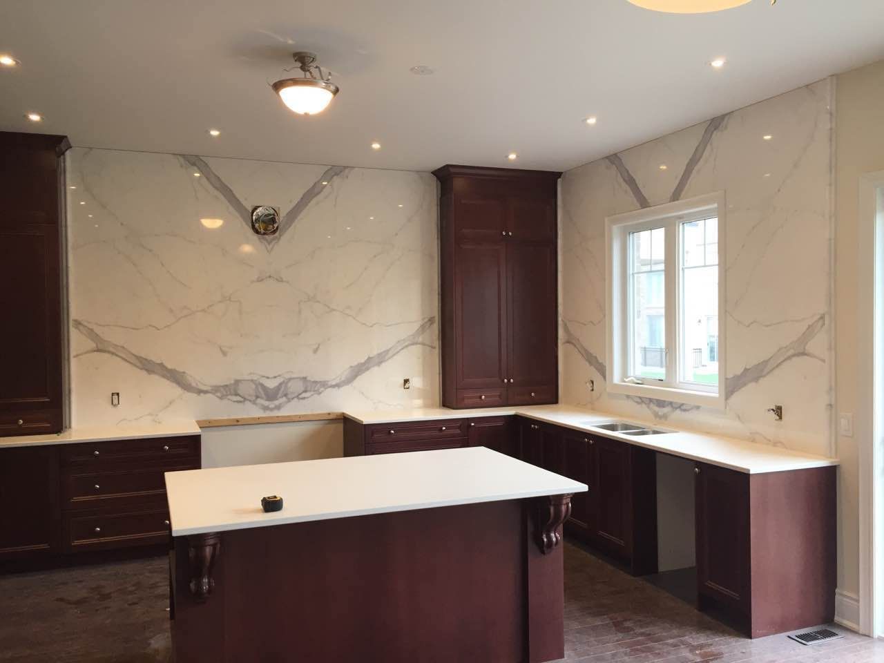 An empty kitchen with a large island in the middle