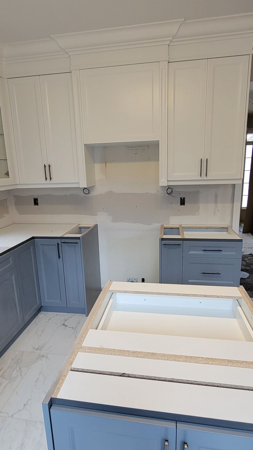 A kitchen with blue cabinets and white cabinets is being remodeled.