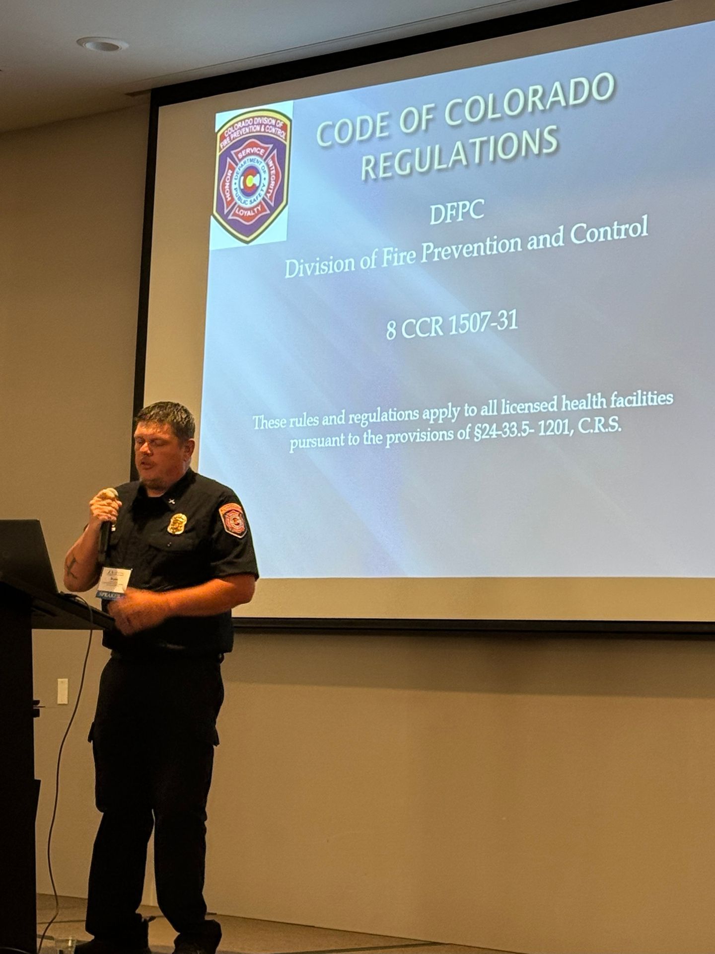 Firefighter presenting at a conference with a projector screen titled 