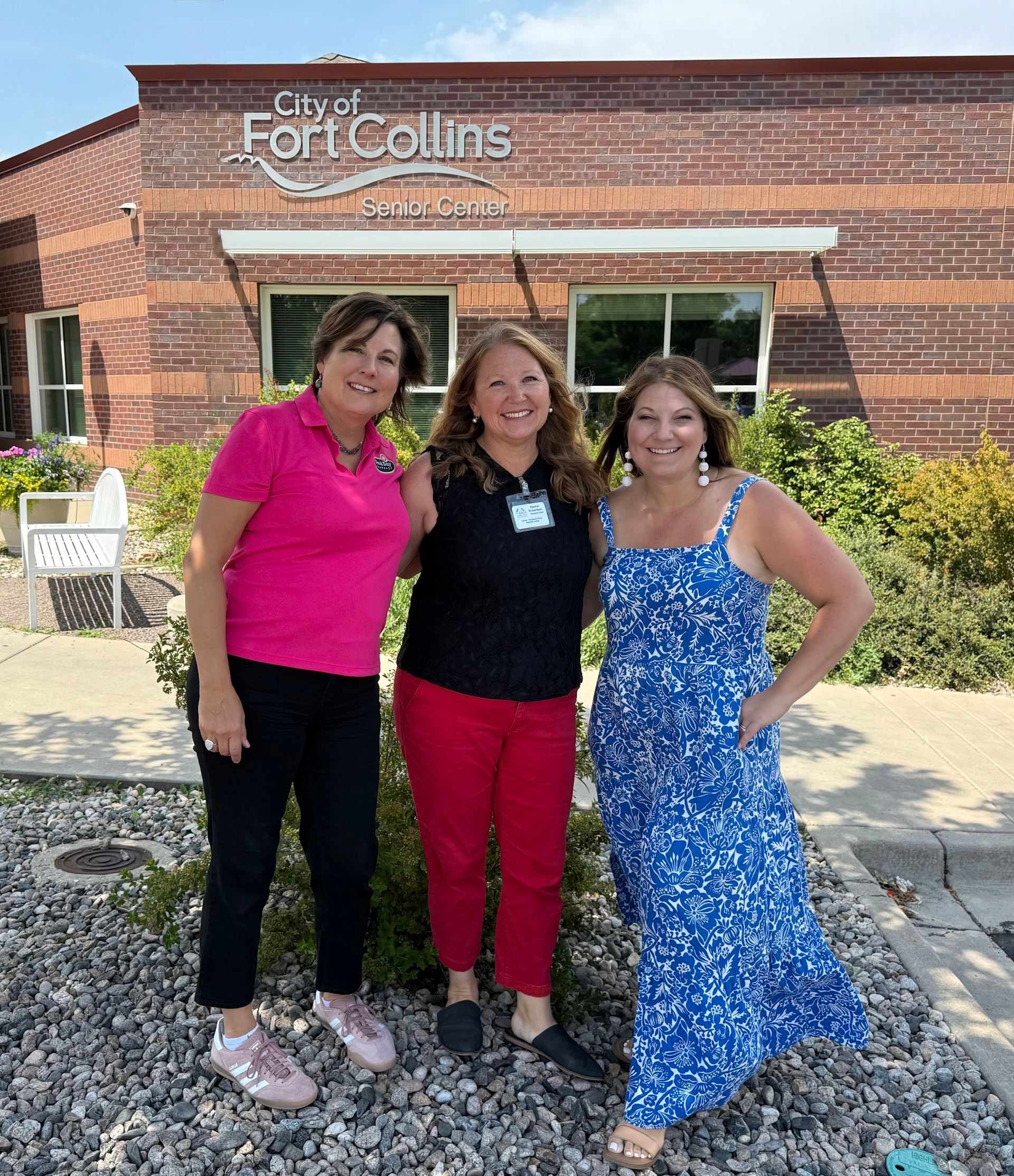 Three women pose in front of the 