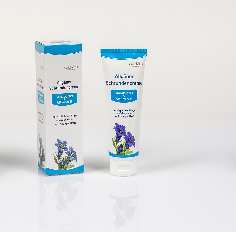 Eine Tube Lotion neben einer Schachtel mit lila Blumen darauf