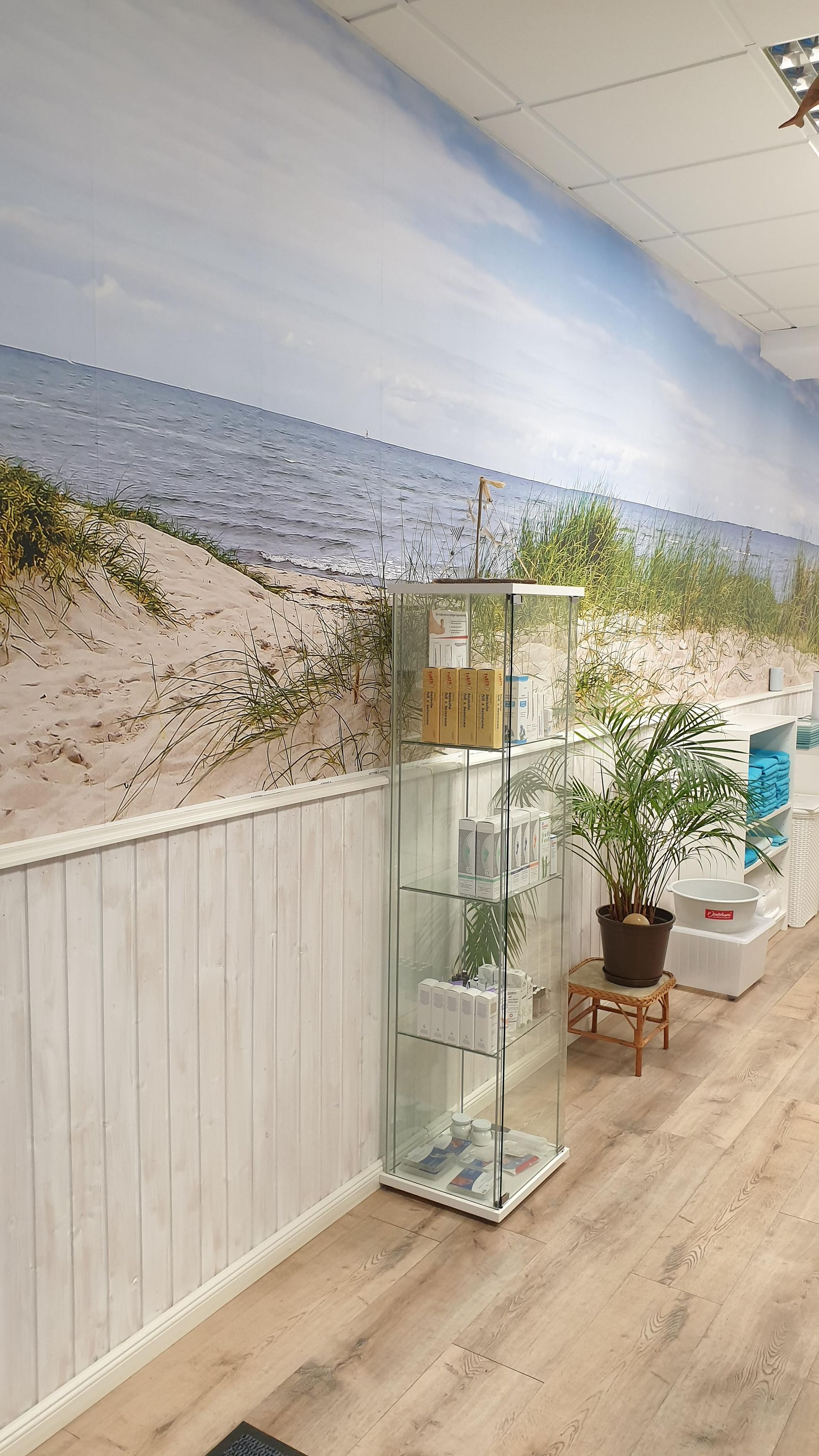 Ein Raum mit einer Glasvitrine und einem Bild von einem Strand an der Wand.