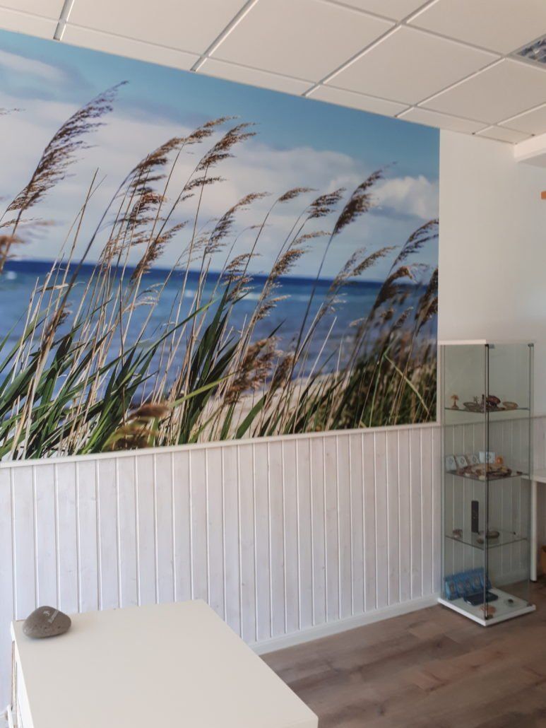 Ein Zimmer mit einem Bild von einem Strand an der Wand