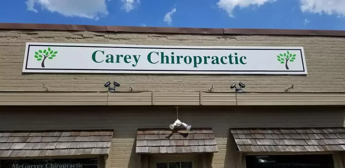 Sign for Carey Chiropractic on a brick building with blue sky.