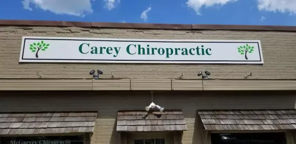 Sign for Carey Chiropractic on a brick building with blue sky.