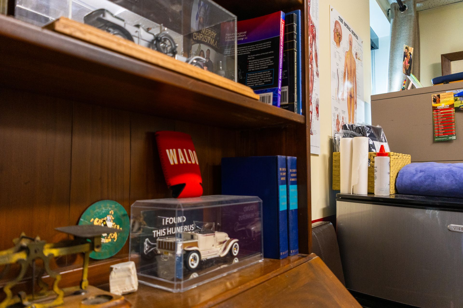 Bookshelf with display items, including toy cars, books, and a red 